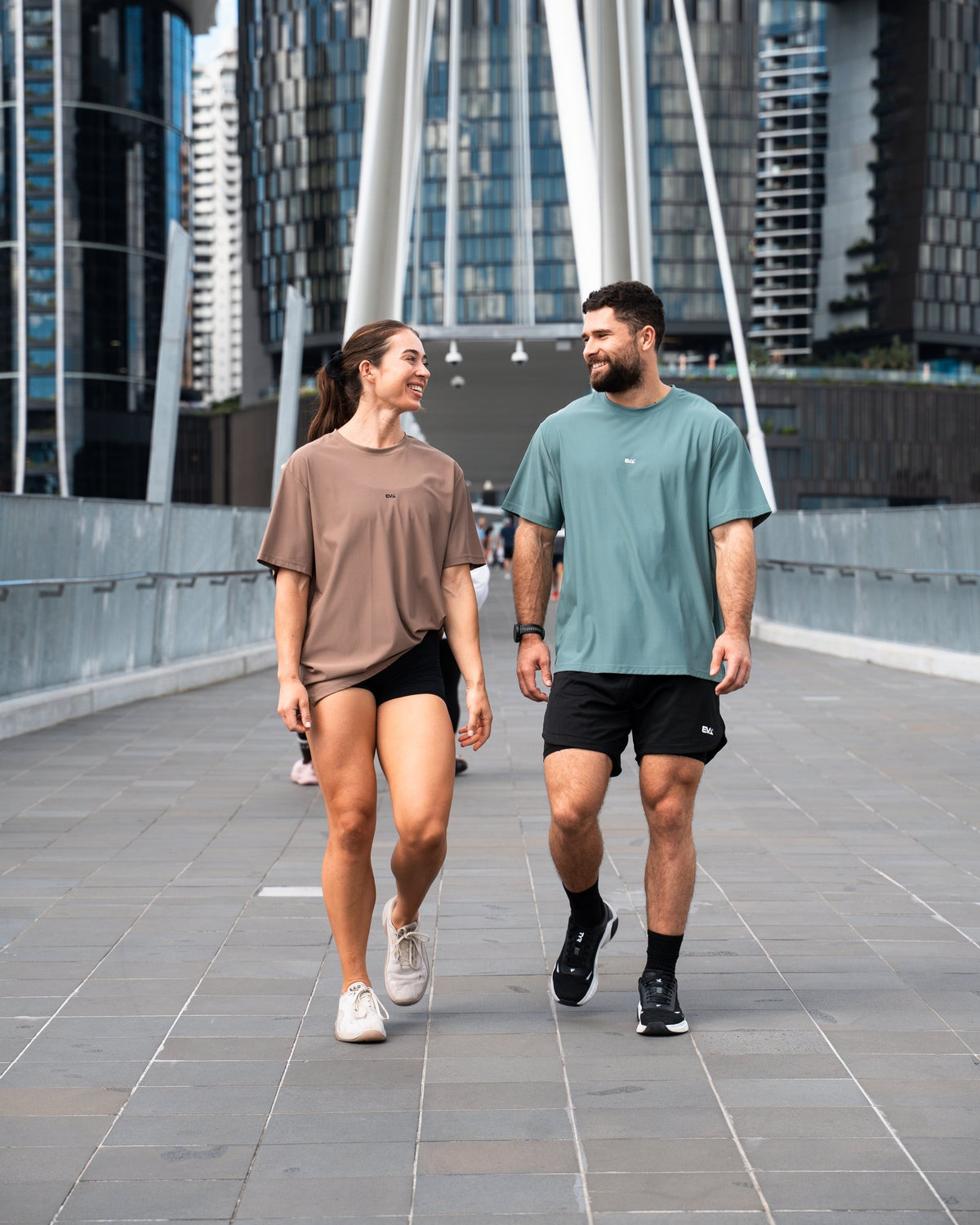 Legacy Oversize Tee in Clay Brown - worn walking across a city bridge