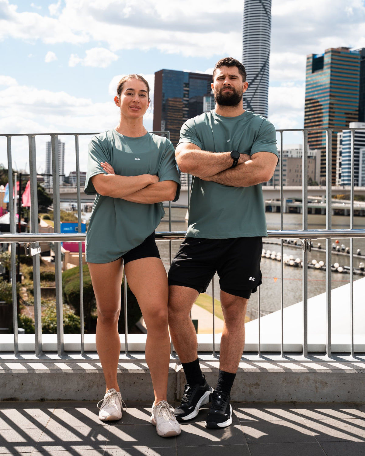Legacy Oversize Tee in Dusty Teal - two models with the city skyline